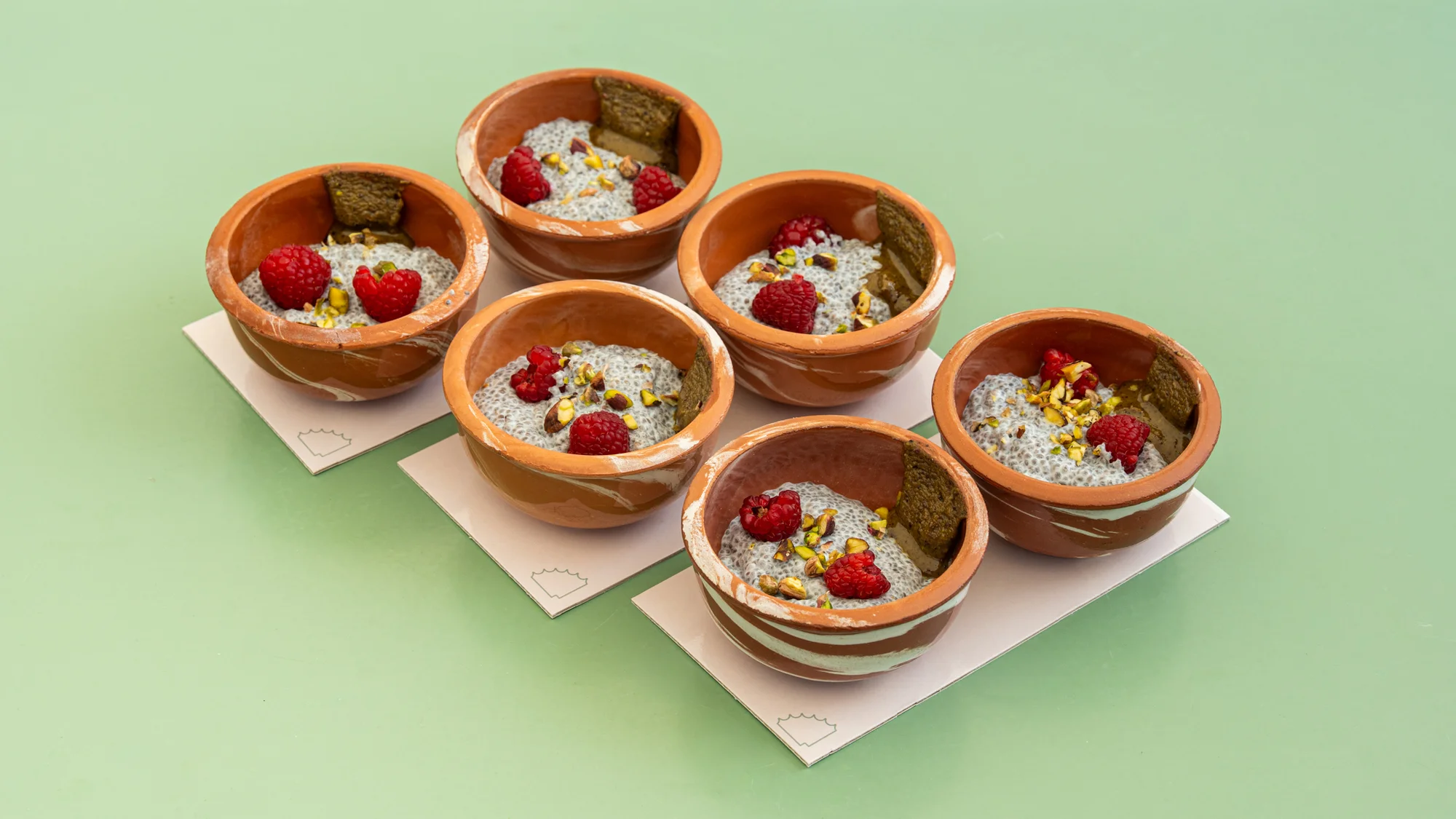 superfood bowls with raspberry pistachio chia pudding in terracotta dishes