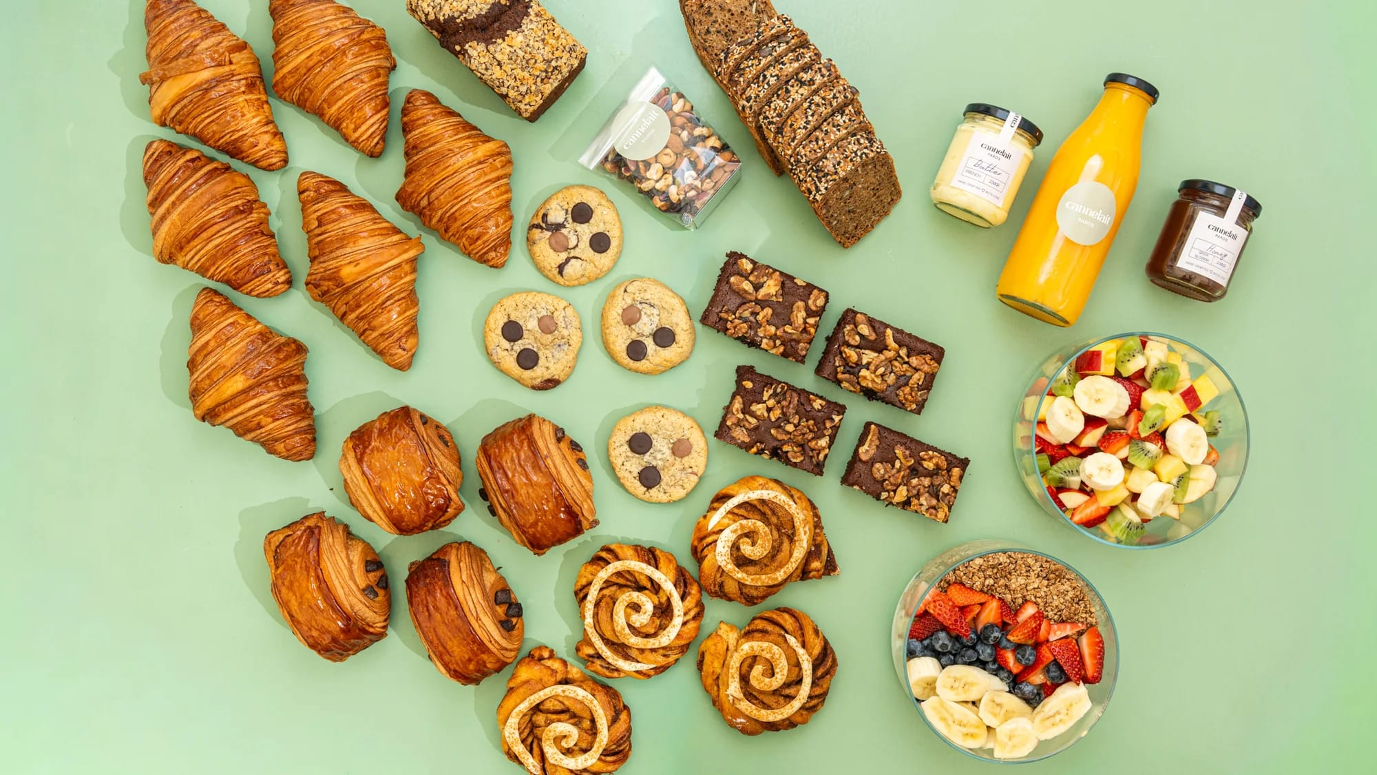 signature breakfast spread with viennoiserie, breads, jams, fruit salad and orange juice